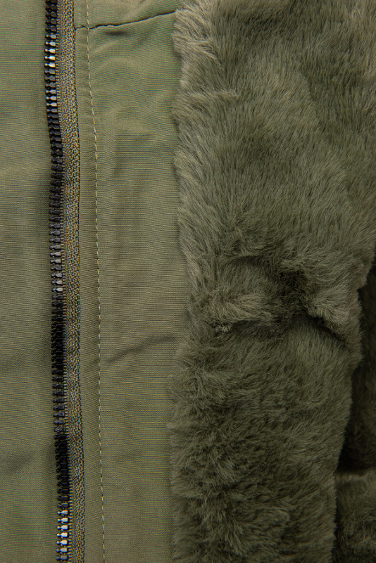 Olívazöld színű parka kapucniján műszőrmével