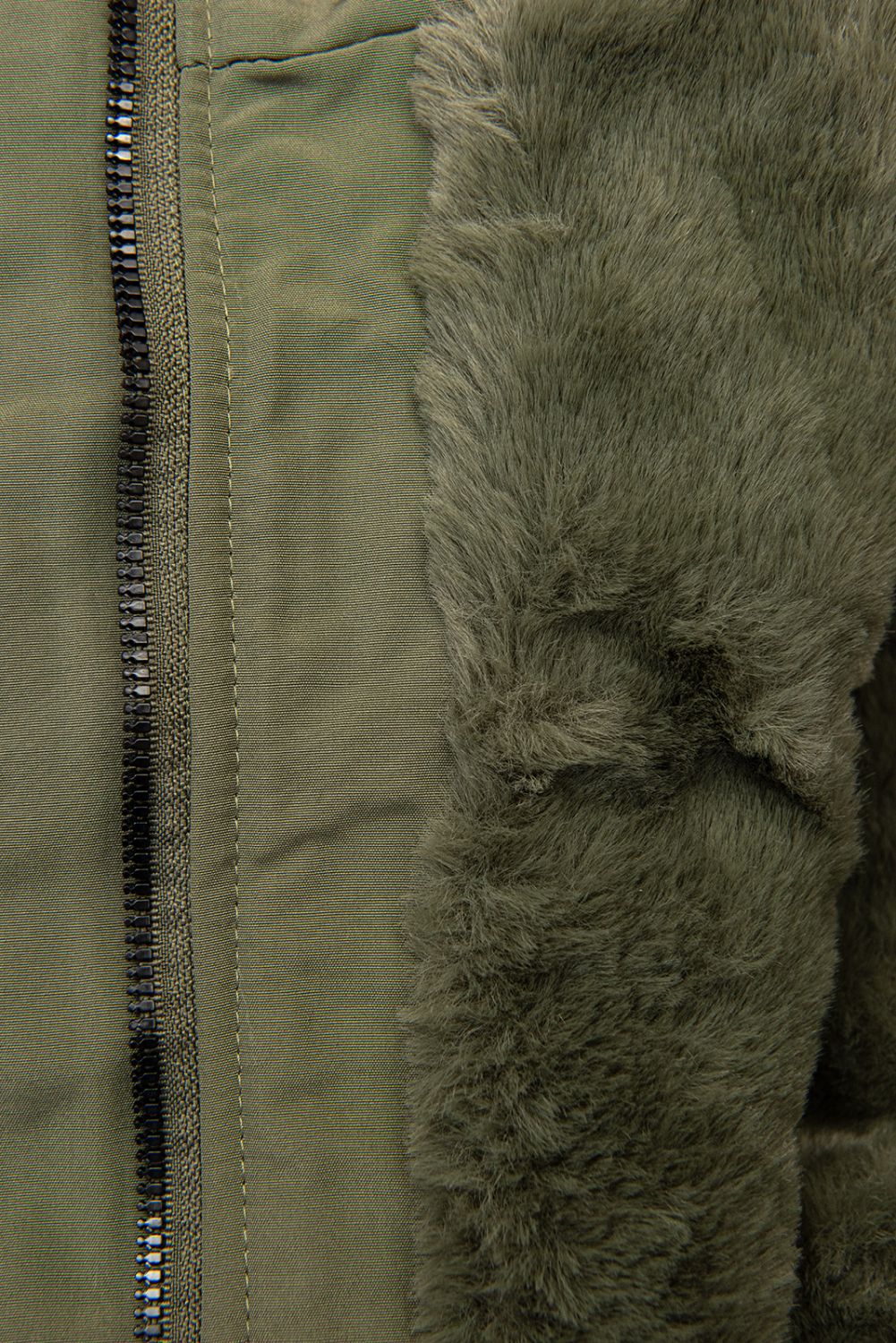 Olívazöld színű parka kapucniján műszőrmével