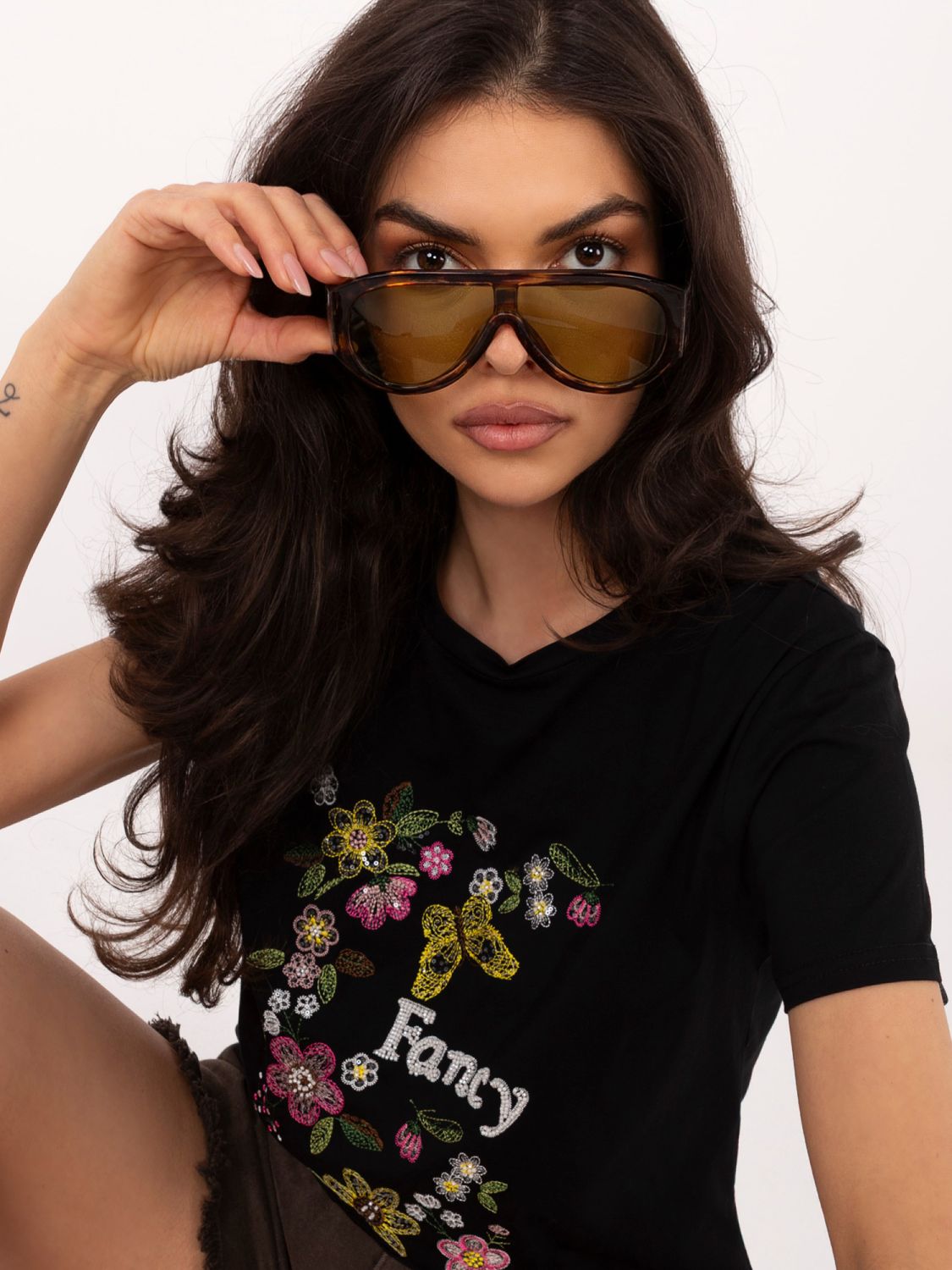 Fekete színű póló applikációval és hímzéssel