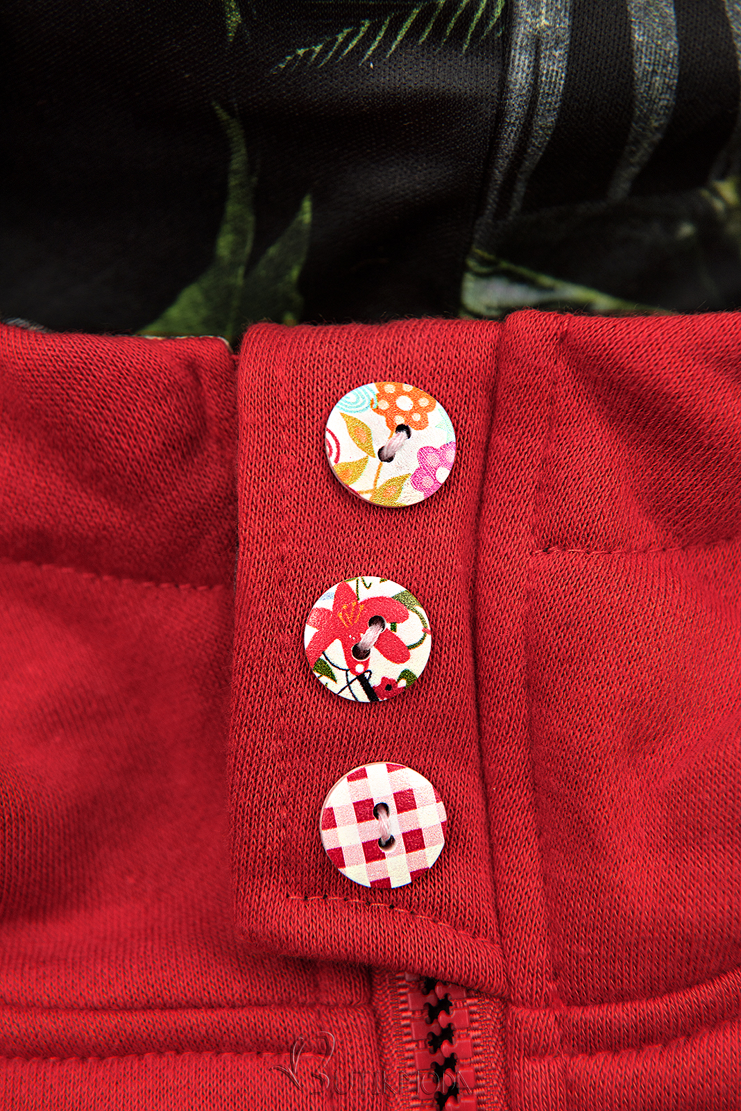 Piros színű felső, kapucniján virágmintás béléssel